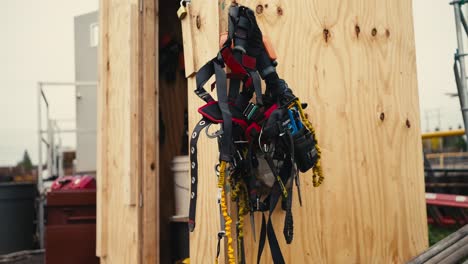 closeup-of-a-safety-climbing-harness-hanging-on-a-wooden-wall