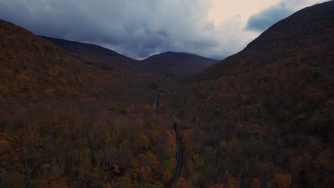 Beautiful-drone-footage-of-a-road-running-through-a-colorful,-autumn-mountain-Valley