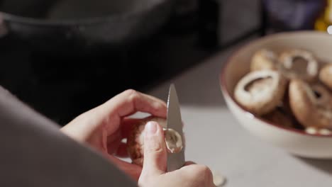 Close-Up-Of-Woman's-Hands-Cutting-And-Cleaning-Mushrooms-In-The-Kitchen