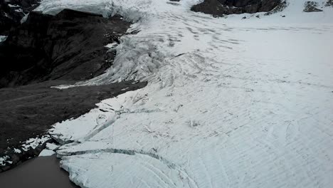Luftüberflug-über-Das-Eis-Und-Den-Gletschersee-Des-Claridenfirn-Gletschers-In-Uri,-Schweiz,-Am-Ende-Eines-Tages-Mit-Einem-Blick-In-Großer-Höhe-Auf-Alpengipfel-Und-Im-Wasser-Schwimmende-Eisberge