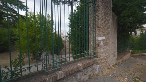 Punto-De-Vista-Inmersivo-En-Roma:-Moverse-Por-Calles-Concurridas-Hasta-Chiesa-Santi-Luca-E-Martina,-Italia,-Europa,-Caminar,-Tembloroso,-4k-|-Caminando-Por-Un-Sendero-Lleno-De-Gente-Cerca-De-Ruinas-Cerradas