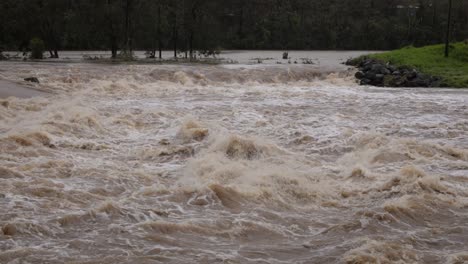 Coomera,-Gold-Coast,-2-January-2024---Turbulent-water,-Coomera-River-Causeway-under-flood-waters-from-the-2024-Storms-in-January