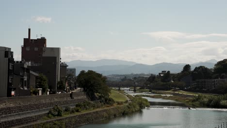 Blick-Auf-Den-Sai-Fluss,-Der-Am-Nachmittag-Durch-Das-Zentrum-Der-Stadt-Kanazawa-Fließt,-Mit-Brücke-Und-Berg-Im-Hintergrund