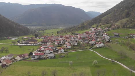 drone-flying-towards-village-in-rural-slovenia-countryside,-early-spring-overcast-day