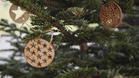 Hölzerne-Weihnachtsdekorationen-Auf-Grünem-Weihnachtsbaum,-Handheld-4k