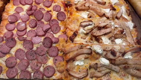 Sliced-pizza-with-various-toppings-on-a-wooden-board