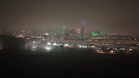 Skyline-Von-Dallas,-Texas-Bei-Nacht-Mit-Nebligem-Wetter-Und-Drohnenvideo-Mit-Stabiler-Weitwinkelaufnahme