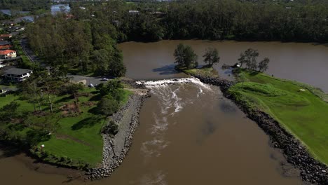 Oxenford,-Gold-Coast,-4-January-2024---Rising-aerial-shot-of-the-Coomera-River-and-Causeway-with-receding-flood-waters-from-the-January-storms