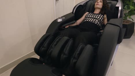 A-Lady-Relaxing-in-a-Massage-Chair---Handheld-Pullback-Shot