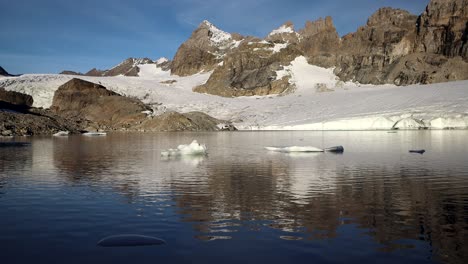 Peaceful-scene-at-the-glacial-lake-next-to-Claridenfirn-glacier-in-Uri,-Swizerland-with-the-alpine-peaks-reflected-and-icebergs-floating