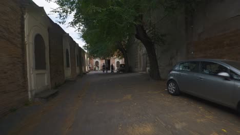 Rome-Immersive-POV:-Moving-In-Busy-Streets-to-Chiesa-Santi-Luca-e-Martina,-Italy,-Europe,-Walking,-Shaky,-4K-|-Car-Parked-In-Shadowy-Area-Near-Church