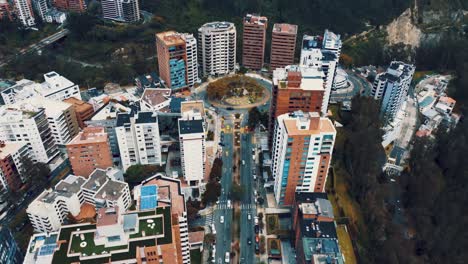 Drone-view-of-a-roundabout-in-the-capital-of-Ecuador,-South-America-with-heavy-traffic
