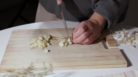 Female-Hands-Cut-Garlic-On-A-Wooden-Board---Close-Up