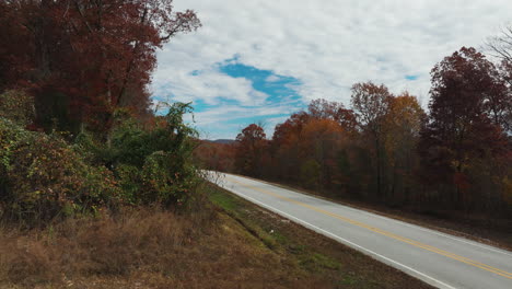 Asphalt-Road-Between-Autumn-Trees-In-AR,-USA---Drone-Shot