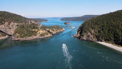 Aerial-revealing-shot-of-boats-passing-under-the-Deception-Pass-in-Washington