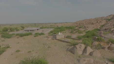 Toma-Aérea-De-Las-Ruinas-Del-Templo-Hindú-En-Nagarparkar-Rodeada-De-Piedras-En-Pakistán.