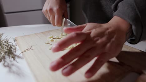 Hands-Cut-Garlic-Into-Small-Pieces-Using-A-Knife---Close-Up