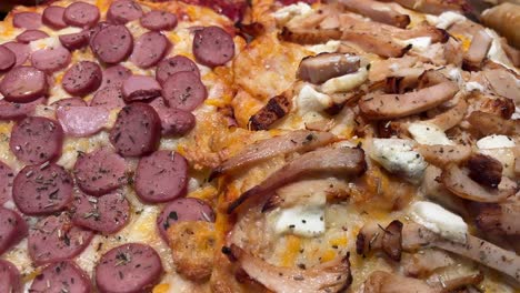 Close-up-of-sliced-pizza-with-meat-toppings-on-a-wooden-surface