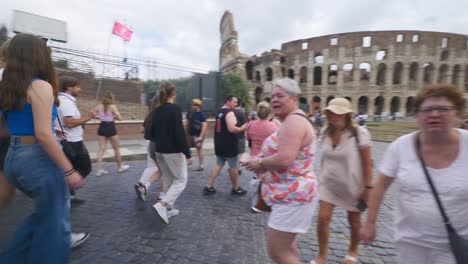 Punto-De-Vista-Inmersivo-En-Roma:-Moverse-Por-Calles-Concurridas-Hasta-Chiesa-Santi-Luca-E-Martina,-Italia,-Europa,-Caminar,-Tembloroso,-4k-|-Gran-Grupo-De-Turistas-Caminando-Cerca-Del-Coliseo.