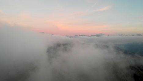 Luftüberflug-über-Wolken-In-Leysin-Im-Waadtland,-Schweiz-Mit-Verschiedenen-Berggipfeln,-Die-Während-Eines-Farbenfrohen-Herbstsonnenuntergangs-In-Den-Schweizer-Alpen-Ein--Und-Aus-Dem-Blickfeld-Verschwinden