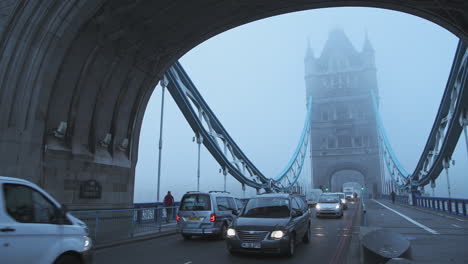 Timelapse-of-Tower-Bridge-in-London,-time-lapse-on-a-foggy-misty-blue-morning-with-mist-and-fog-moving-and-traffic-driving-on-first-day-of-Coronavirus-Covid-19-Lockdown,-England,-Europe