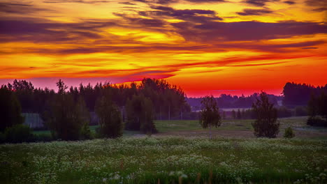 Stunning-colorful-sunset-over-a-misty-countryside-meadow-and-forest---time-lapse