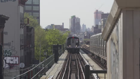 Tren-Tirando-En-La-Estación-De-Metro-Al-Aire-Libre-Con-Brooklyn-En-Segundo-Plano.