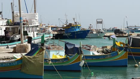 Pequeños-Y-Grandes-Barcos-Pesqueros-Coloridos-Flotando-En-El-Puerto-De-Marsaxlokk.