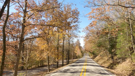Driving-Into-Empty-Asphalt-Road-During-Autumn-Near-Devil's-Den-State-Park,-Arkansas-USA