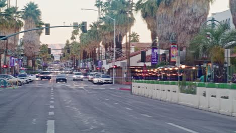 Wide-shot-of-cars-driving-in-downtown-Palm-Springs,-California-in-slow-motion-with-lens-flare-effect