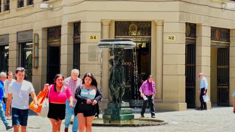 People-walking-in-La-Bolsa-neighborhood-with-cobblestone-streets-and-old-fountains-in-Santiago-Chile---New-York-aesthetics