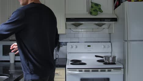 Hombre-Limpiando-La-Encimera-De-La-Cocina-Dentro-Del-Apartamento
