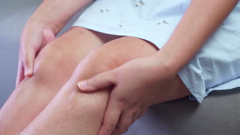 Close-up-of-an-individual-squeezing,-pressing,-and-pinching-her-knees-to-relieve-the-swelling-and-inflammation