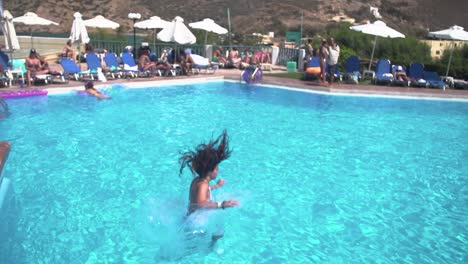 Girl-Jumping-into-a-Pool-during-the-Summer,-Slow-Motion