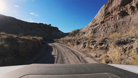 POV-Driving-4x4-SUV-Along-Dirt-Road-in-Utah,-Factory-Butte-shot-with-DJI-Action-4