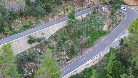 Aerial-View-Of-Motorcyclist-Driving-Mountain-Twisted-Road-In-Majorca-Mountains