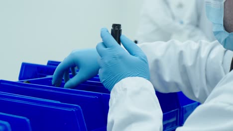 Labortechniker-In-Laborjacke-Und-Blauen-Medizinischen-Handschuhen-Verpackt-Vorgerolltes-Cannabis-In-Eine-Tube,-Die-In-Apotheken-Verkauft-Wird