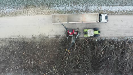 Aerial-view-of-wood-chipper-blow-shredded-wood-into-truck-cargo-trailer