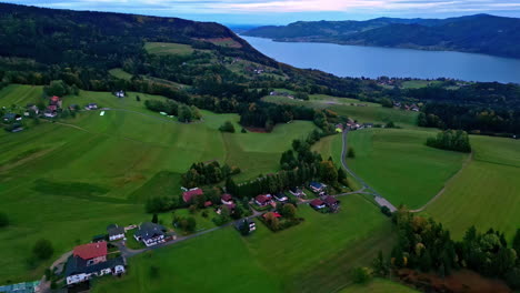 Drone-dolley-tilt-shot-over-the-green-valley-in-Austria-with-the-Attersee-in-the-background