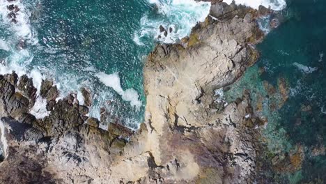 Aerial-top-down-shot-of-Pacific-Ocean-with-crashing-waves-against-rocky-coastline-in-Mexico