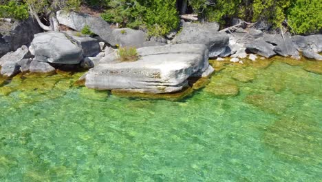 Clear-waters-of-Lake-Huron-washing-the-Bruce-Peninsula-Shoreline,-Aerial-Dolly-Left-to-Top-Down-Shot