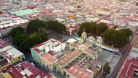 Aerial-flyover-beautiful-city-of-Oaxaca-de-Juárez-with-park,-historic-old-town-and-cathedral---tilt-down