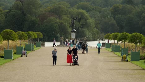 Families-Walking-On-The-Walkway-Of-Italian-Garden-In-Trentham-Gardens,-Perseus-and-Medusa-Statue-In-The-Background