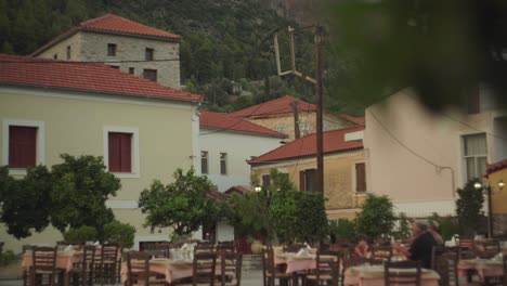 Older-gentlemen-enjoy-afternoon-meal-in-scenic-Mediterranean-town-at-an-empty-outdoor-restaurant