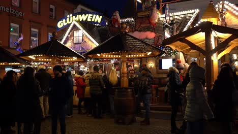 People-gathered-in-warm-vibe-drinking-wine-at-Christmas-market-at-night