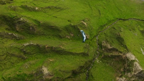 Drone-view-above-paraglider-soaring-over-lush-Achill-Island-terrain,-Ireland