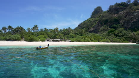 Monuriki-island-in-Fiji-with-a-boat-departing-the-beach-island-hopping-between-islands