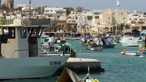 Fisherman-Working-On-Fishing-Net-In-The-Harbor-Of-Marsaxlokk