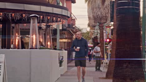 Wide-shot-of-pedestrians-walking-in-downtown-Palm-Springs,-California-with-stable-shot-and-lens-flare-effect