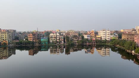 Toma-Aérea-De-Vista-Panorámica-De-Apartamentos-Cerca-De-Un-Estanque-En-Kolkata,-India.